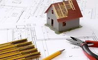 BLueprints and a model house with an incomplete roof.  