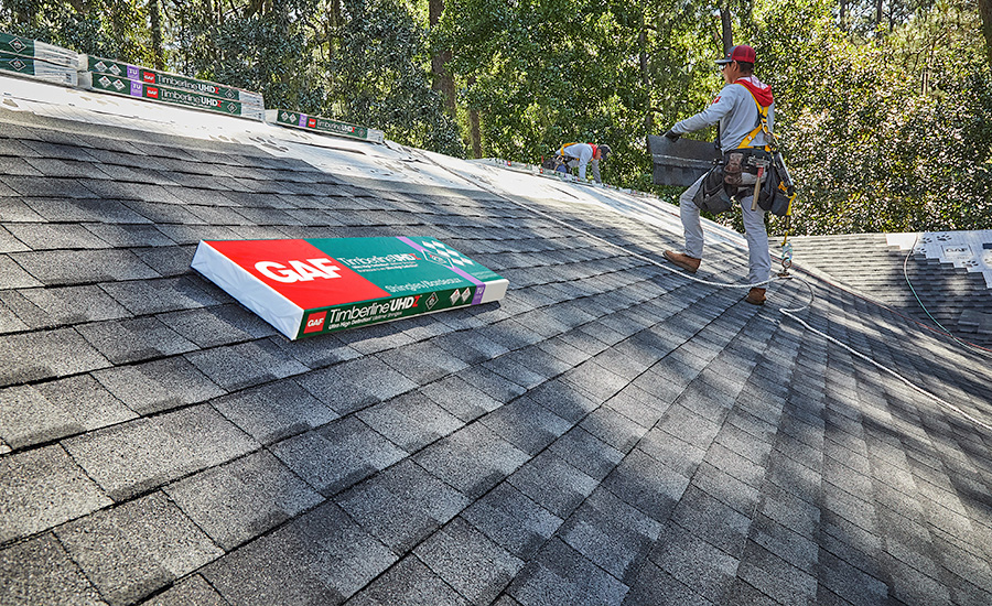 A package of GAF Timberline asphalt shingles being installed on a roof.