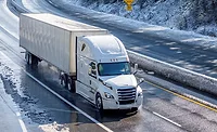A picture of a long-haul truck driving down the road