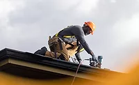 A man working on a roof A man working on a roof