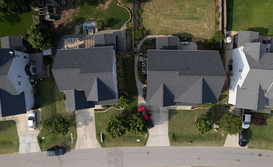 A man nails shingles to a roof