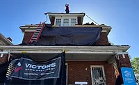 A roofer from Victor’s Home Solutions stands on a roof the company is replacing in coordination with Habitat for Humanity..
