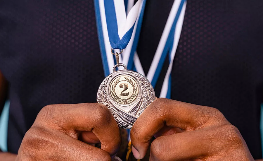 A man in a suit holding a medal