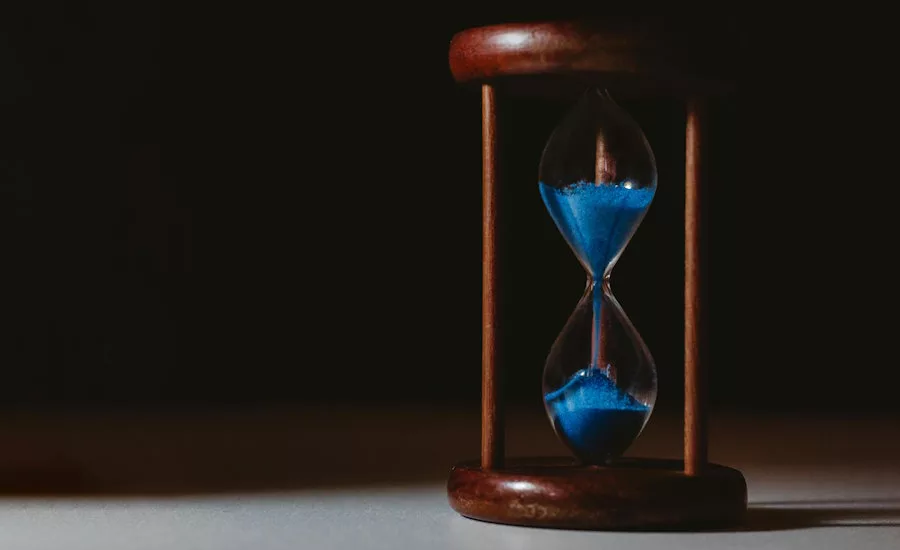 hourglass-with-blue-sand-black-background