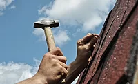 Hammer, nail, roof A hand holding a hammer, preparred to put a nail in a roof