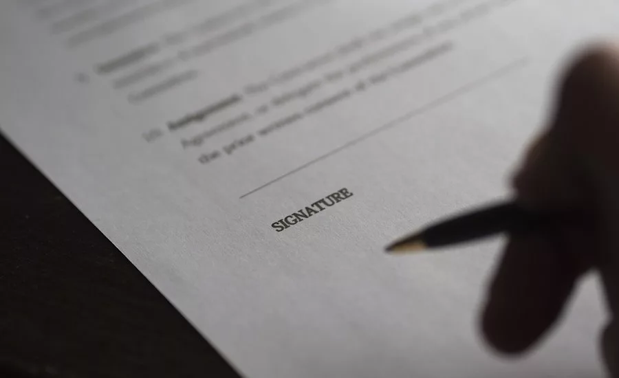 hand-with-pen-signing-contract
