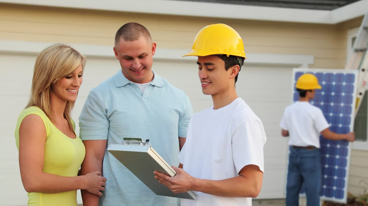 A contractor discusses a roofing job with homeowners
