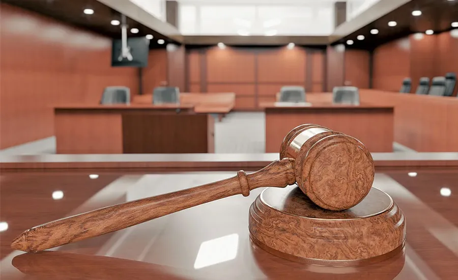 A gavel resting on the judge's bench in a coutroom