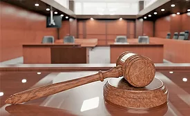 A gavel resting on the judge's bench in a coutroom