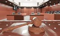 A gavel resting on the judge's bench in a coutroom
