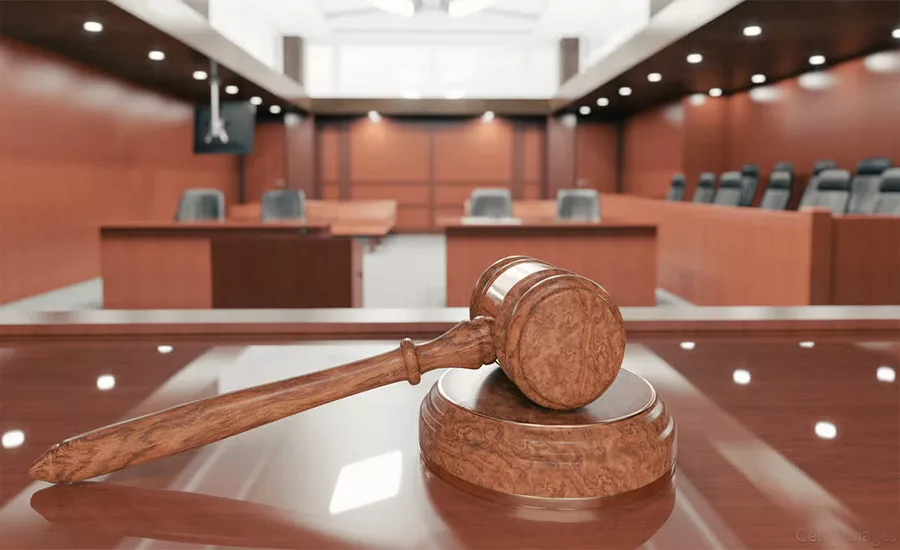 A gavel resting on the judge's bench in a coutroom