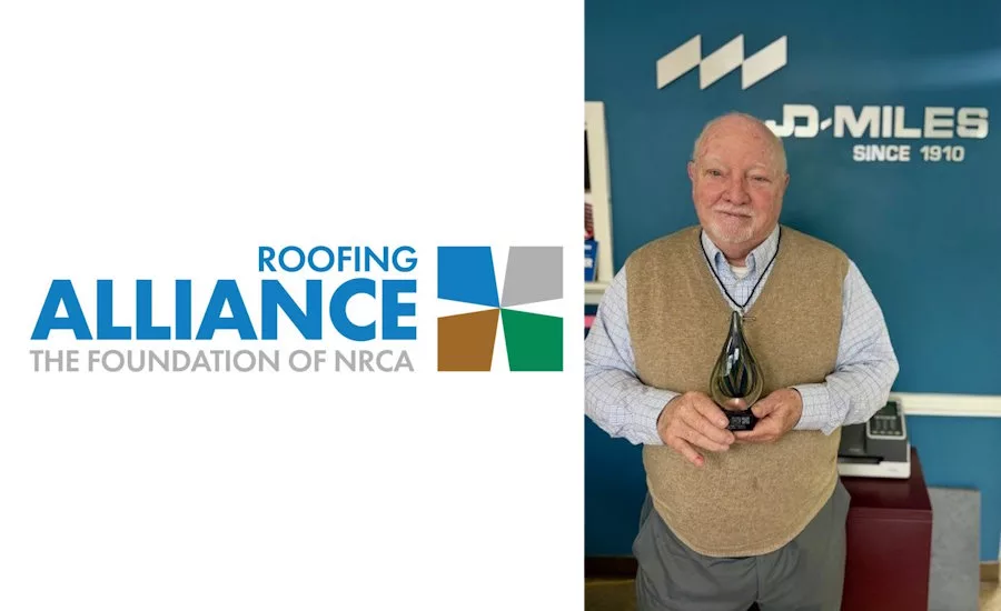 Dudley-Miles-at-his-comapny-lobby-holding-Bennett-Award