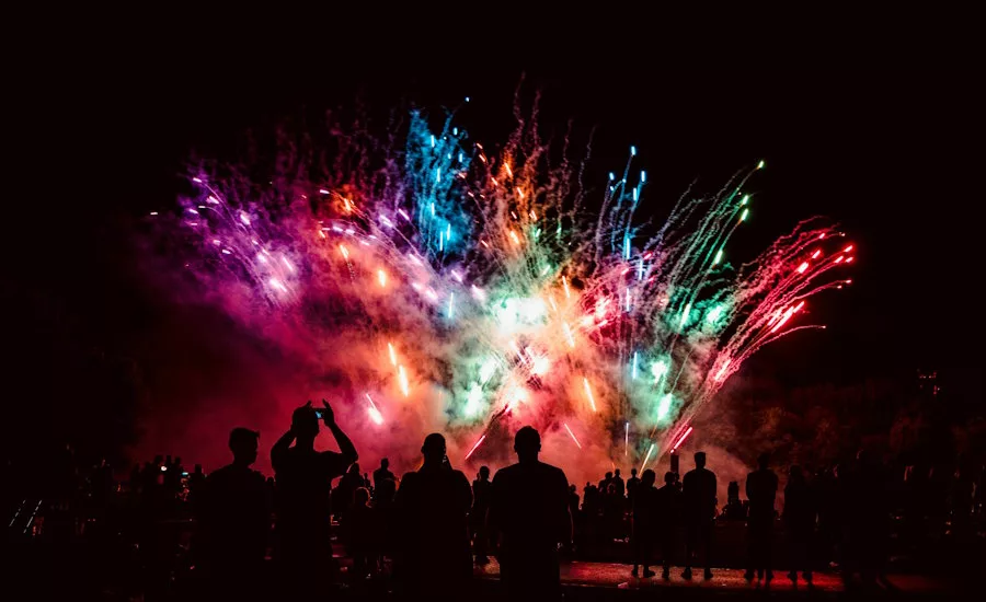 low-fireworks-in-the-sky-as-people-watch-and-film-on-phones