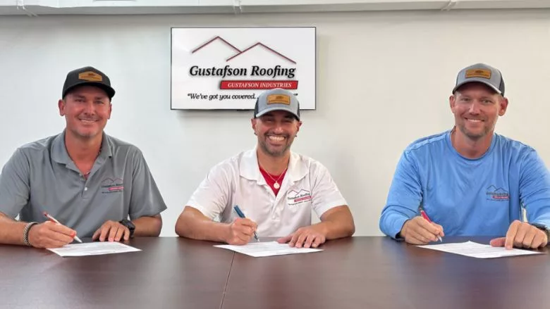 The teams at Stronghouse and Gustafson Roofing signing contracts