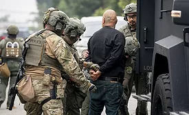 ICE-officers-in-uniforms-arresting-man