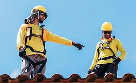 two-roofers-in-harnesses-on-tile-roof