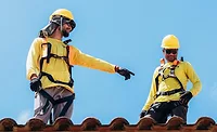 two-roofers-in-harnesses-on-tile-roof