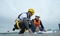 Courtesy of S-5!.jpg Two construction workers looking at plans