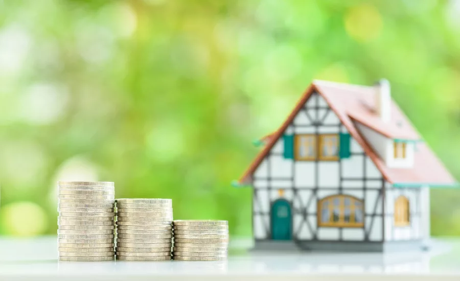 coins-stacked-next-to-model-house
