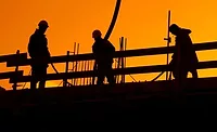 Construction works on a roof at sunset