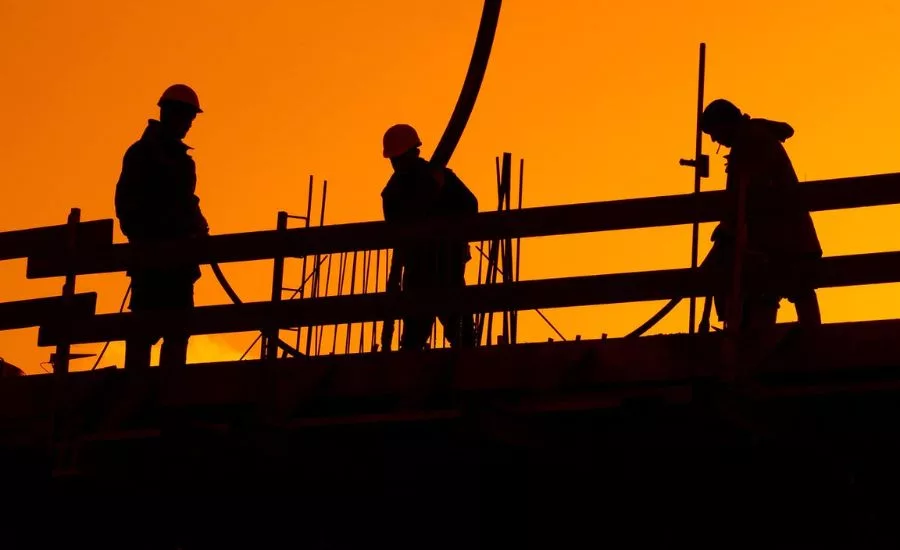 Construction works on a roof at sunset
