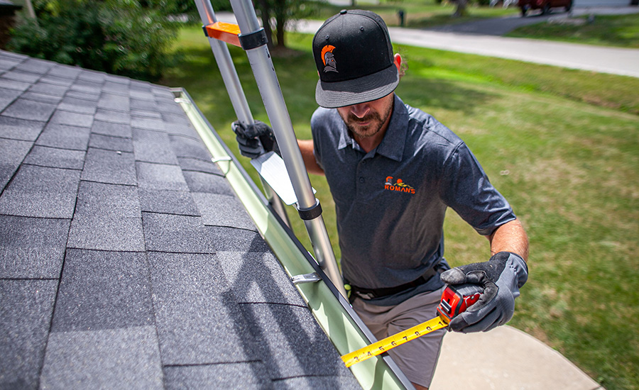 A man taking measurements on a roof