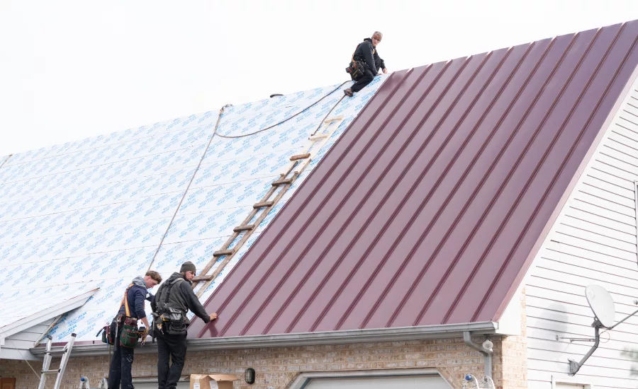 Workers-installing-metal-roof-on-steep-slope-building