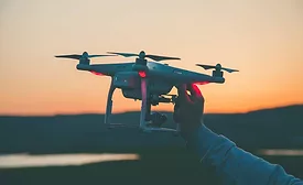 drone-held-by-a-hand-against-sunset