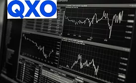 QXO-logo-overlaid-with-finance-reports-on-computer