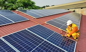 man-wearing-safety-gear-installing-solar-panels-on-roof