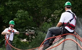 two contractora applying roof rejuvenation product to a residential roof