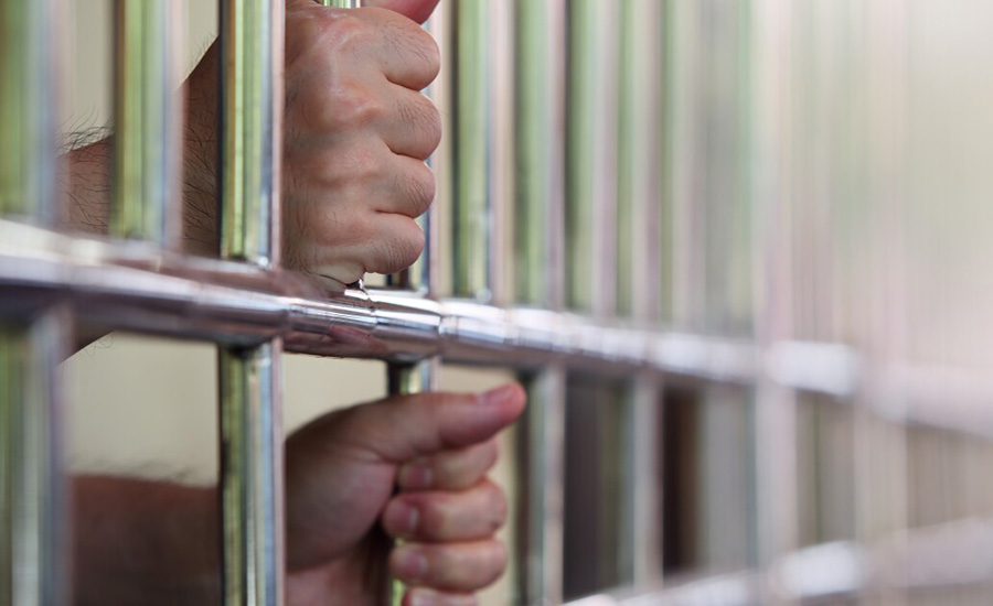 hands holding prison bars