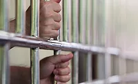 hands holding prison bars