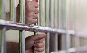 hands holding prison bars