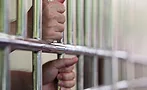 hands holding prison bars