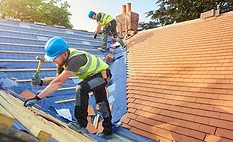 contractors on a roof installing shingles