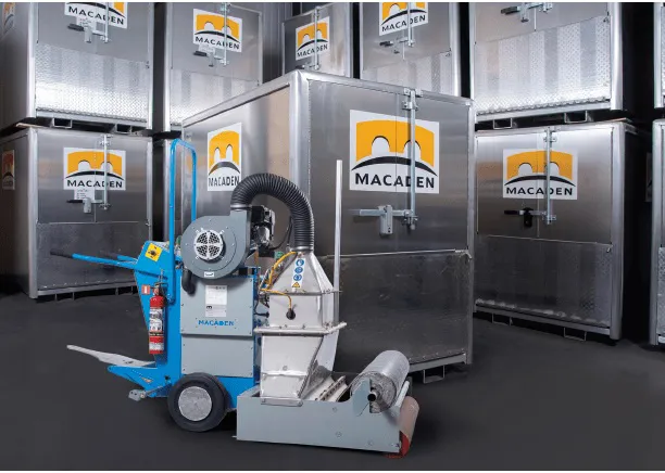 A blue and grey industrial machine for material handling, surrounded by silver Macaden containers.