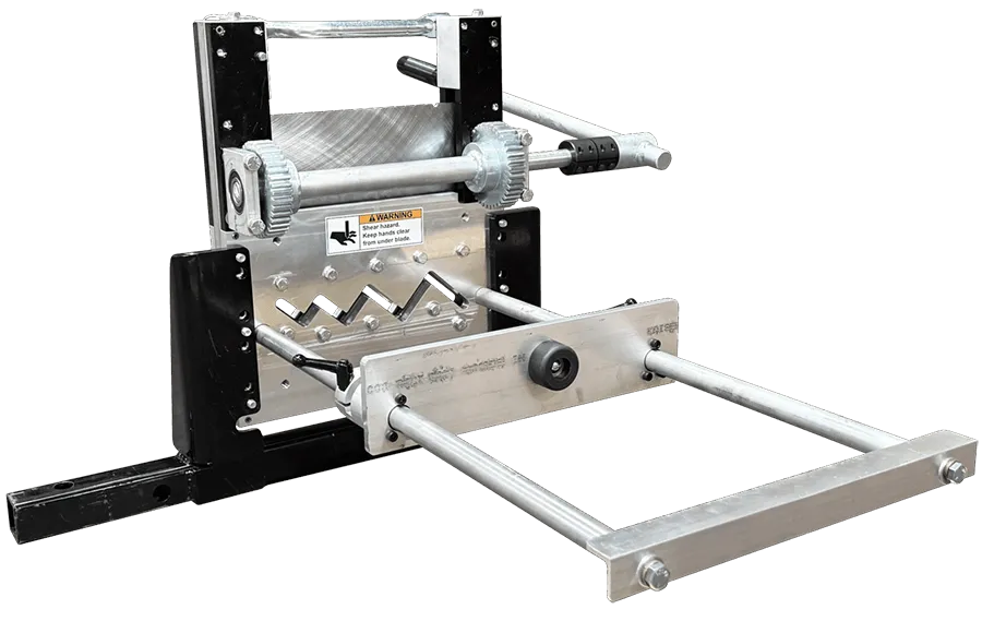 Industrial metal shear machine with zigzag blades and front guides, featuring a warning label.