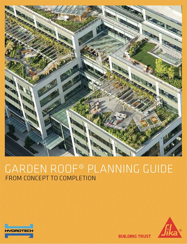 Aerial view of a building with multiple green garden roofs, featuring outdoor seating and walkways.