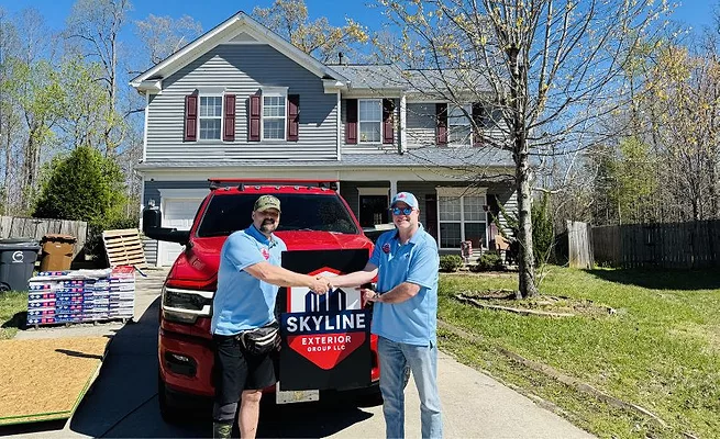 Skyline rep and homeowner shaking hands at the reroofing site