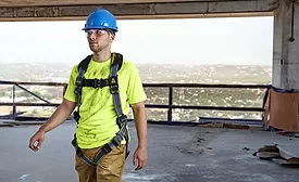 Worker wearing a Werner fall protection harness designed for construction and roofing jobsites.