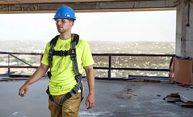 Trabajador usando un arnés de protección contra caídas Werner diseñado para sitios de construcción y techado. Worker wearing a Werner fall protection harness designed for construction and roofing jobsites.