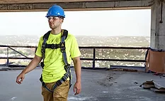 Worker wearing a Werner fall protection harness designed for construction and roofing jobsites.