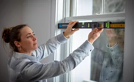 Woman using the OX Pro SPEEDFRAME on a window. 