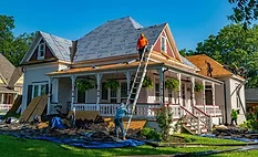 roofers replace shingles on a home