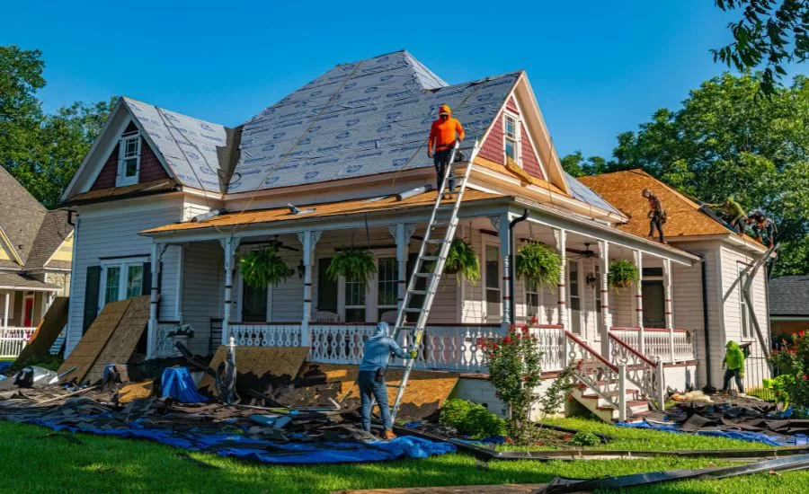 roofers replace shingles on a home