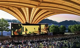 Rendering of Vancouver's Freedom Mobile Arch amphitheater showing a large crowd beneath the sweeping mass-timber roof with mountains visible beyond the stage.