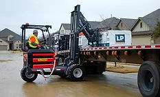 A forklift unloading roofing shingles