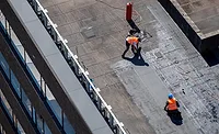 Roof Restoration Index Birds eye view of a roof construction site. Professional bitumen waterproofing on a flat building.
