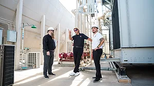 3 men standing on a loading dock near a semi truck
